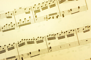 Obraz premium Vintage sheet music notation manuscript with staff lines and gently moving musical notes. This retro, grunge styled motion background is a seamless loop.