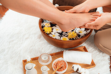 Woman indulges in blissful foot massage at luxurious spa salon while masseur give reflexology therapy in gentle day light ambiance resort or hotel foot spa. Quiescent