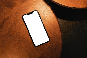 Smartphone with Blank White Screen on Wooden Table Background 