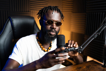Radio host adjusting microphone while recording podcast in studio