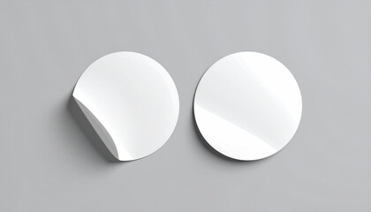 Two blank white round sticker mockups with one peeling off, isolated on a grey background. Template for branding and logo design presentation