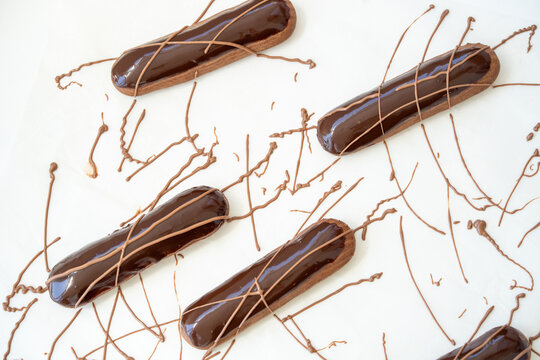 Delicious Chocolate Eclairs Artistically Arranged on a White Surface