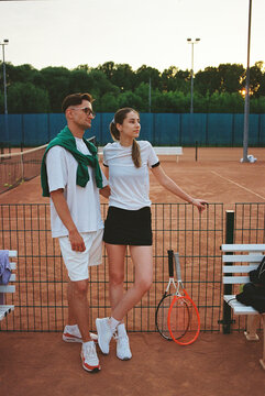 Young couple enjoying a moment on a tennis court during sunset