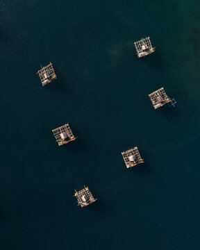 Aerial View of Traditional Fishing Huts surrounded by Calm Water