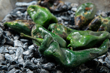 Roasting poblano peppers on charcoal for authentic mexican flavor
