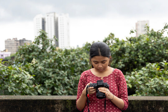 Young Indian woman previewing photographs in mirrorless camera