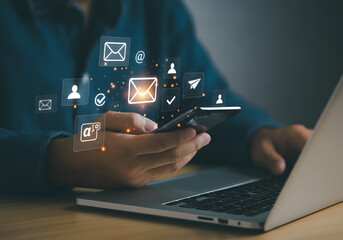 Person interacting with digital icons over a laptop and phone