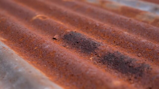 Rusty Corrugated Metal Texture - Close-up view of a weathered corrugated metal surface showing parallel curved lines.
