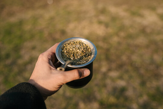 Anonymous hand holding mate outdoors on blurred background
