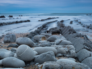 Layered rock formations on a Spanish coast - A long exposure shot of the striking flysch rock formations on the Basque coastline, with the gentle blur of the rising tide.