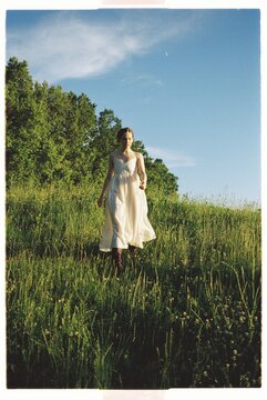 Woman walking through lush grass in a beautiful summer landscape