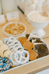 Variety of sweet treats displayed on a wooden table at a cozy dessert shop during a sunny afternoon