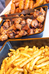 Sizzling street food feast: grilled sausages, shashlik, and golden french fries