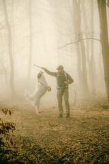 happy dog and owner in foggy forest