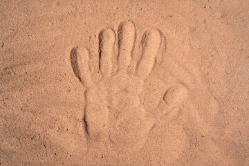 Human handprint on sand surface