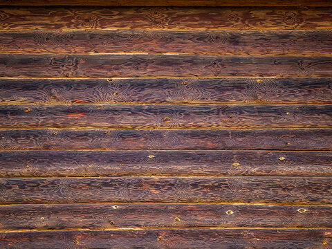 Texture of a log house wall. Long, strong, even logs are laid in layers horizontally on top of each other. Wooden log background. Copy space.