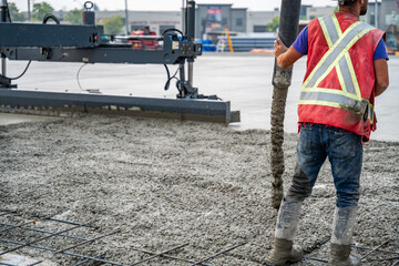 Fototapeta premium Worker on Concrete Pour Process on a Construction Site