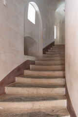 Interior detail of staircase leading up between whitewashed walls