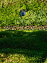 Green roof of traditional Icelandic turf house with window - Hof, Iceland