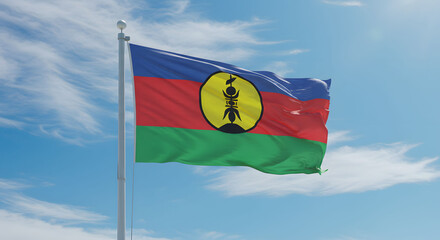 The New Caledonia flag waving from a white flagpole. A cloudy blue sky in the background. 24 September New Caledonia National Day.