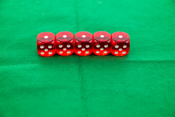 Red dices on green background, symbolizing casino games, gambling, and poker tournaments.