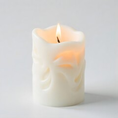 Warm glow from a burning white candle with elegant carved design