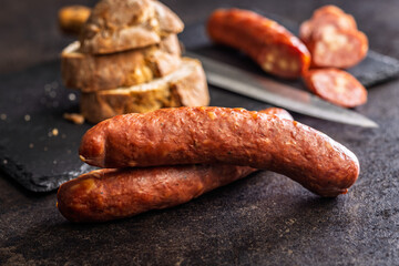 Smoked sausages on black table.