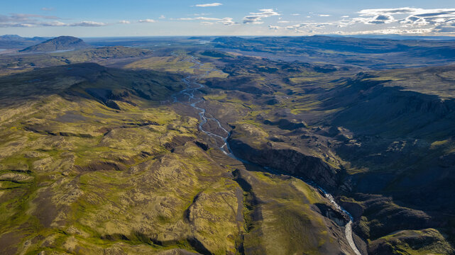 Scenic landscape of Iceland with river flowing through deep canyon near H&aacute;ifoss and Granni waterfalls surrounded by vast volcanic highlands