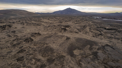 Volcanic desert landscape in Iceland with distant mountain under cloudy sky showing barren lava plains, rugged highlands, and wild scenery