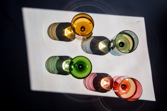 Primary coloured glasses photographed from above in hard light.