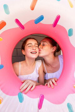 Sisters sharing a joyful moment through pool float