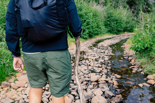 Lower body of an unknown person stepping through a muddy uneven path