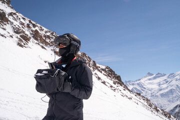 FPV pilot flying drone in alpine landscape