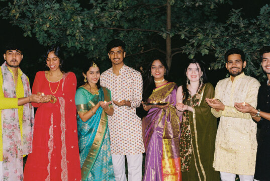 Group of Indian friends with sparkles celebrating Diwali night.