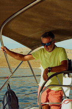 Man is steering a sailboat