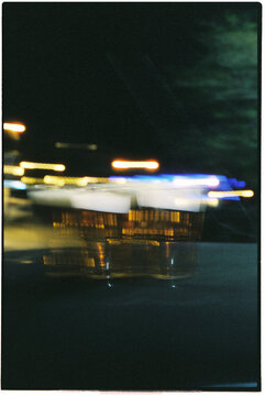 a pair of beer cups on a car roof under neon lights, 35mm