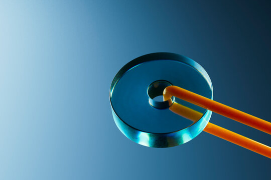  Glass Ring Pierced by Dual Orange Tubes on Blue