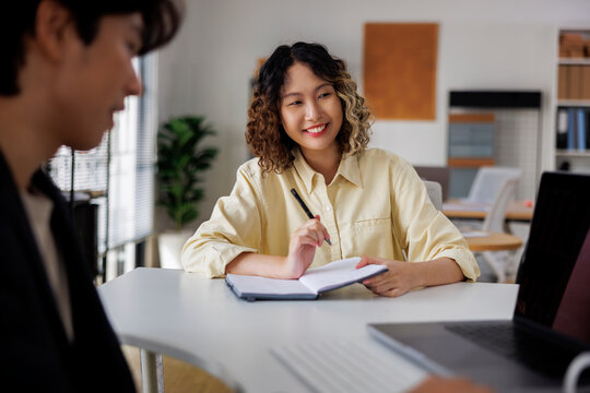 Smiling woman takes notes during a meeting.