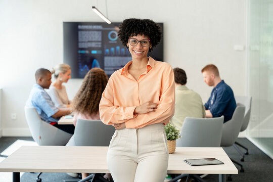 Confident businesswoman leading multicultural team in modern office