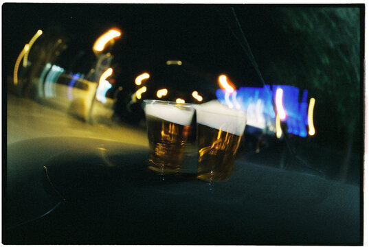 two plastic beer cups among city lights at night, 35mm