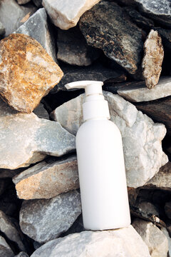 White cosmetic bottle on natural stones