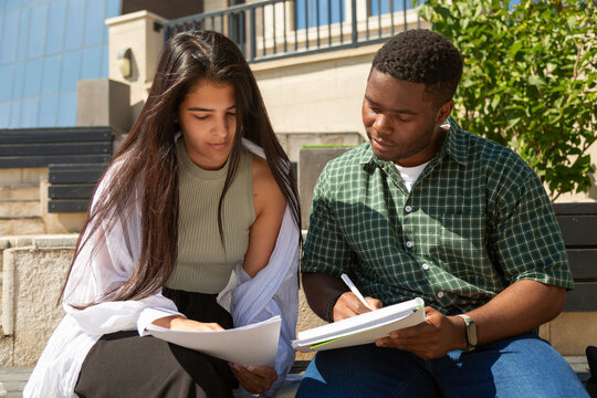 Focused students studying together outdoors