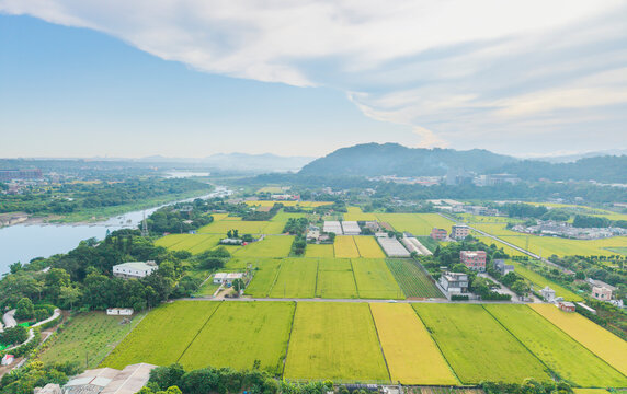 Aerial View of Green Fields River and Distant Hills Under Clouds