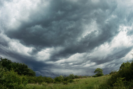 Heavy storm clouds over green landscape