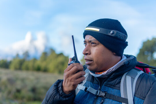 Mountain guide using walkie talkie during a hike