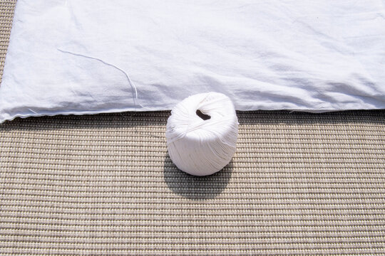 A woman is sewing a quilt with a needle and thread.