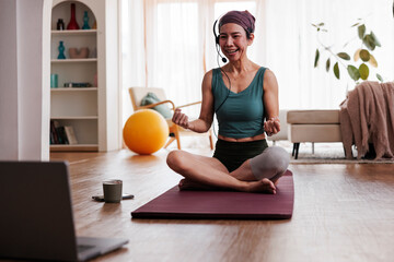 Woman leads online yoga class from home.