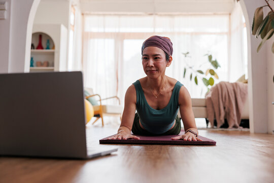 Woman doing yoga with online class at home.