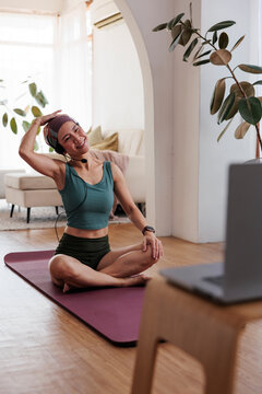 Woman doing online yoga class at home.