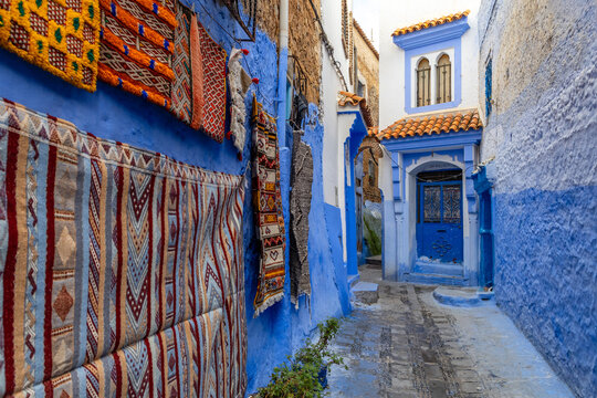 Colorful rugs on blue alley in Chefchaouen
